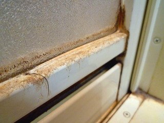 1. 浴室(お風呂場)のドア(写真は室外側）の桟部分に積もった複合汚れ。かびであればカビ取りジェルの出番ですが、茶色＆白っぽいのは水垢の可能性が大。試しに爪でかりかりしてみるものの、まったくビクともしません。